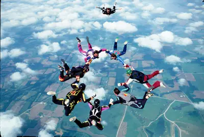 persone in cerchio che fanno skydiving in caduta libera in cielo